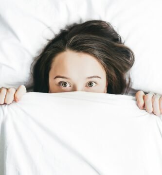 woman covering her face with blanket