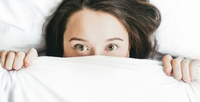 woman covering her face with blanket